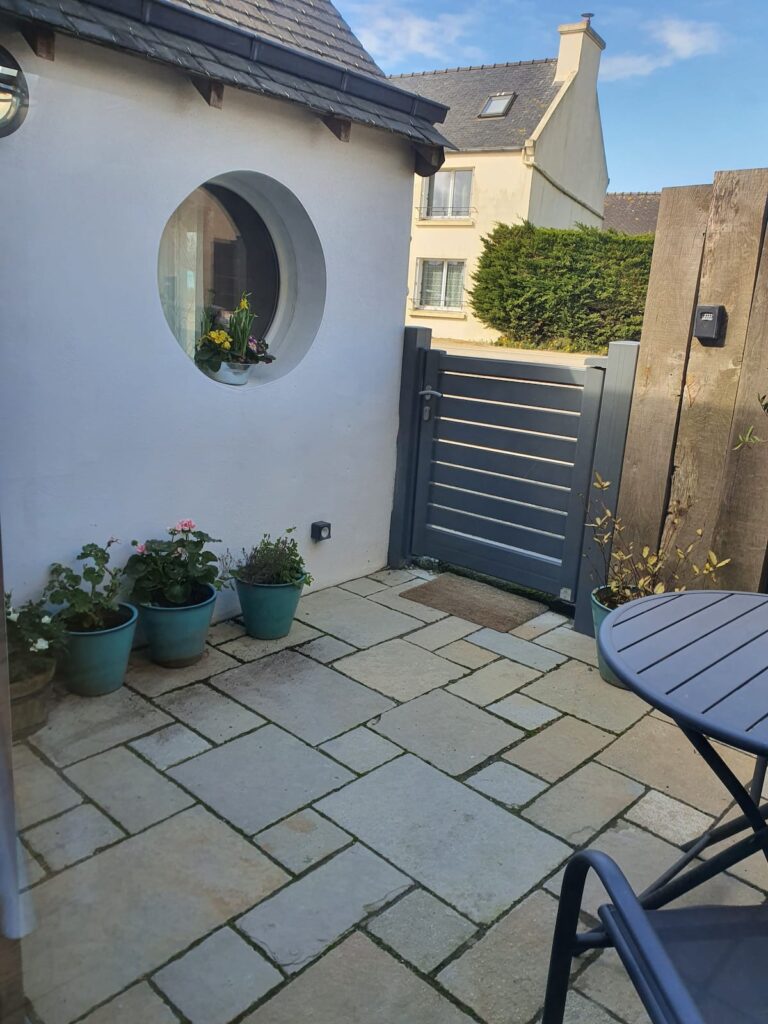 Vous voici chez Vous ! Une première terrasse avec des géraniums et des roses, des primevères et des jonquilles... Une prise électrique extérieure pour recharger vos vélos électriques ou brancher votre plancha de table.