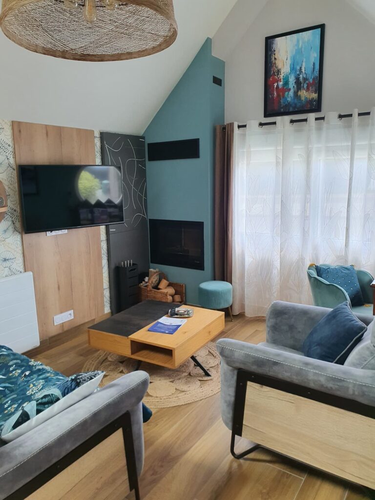 Un salon confortable. avec une table basse télescopique qui devient déjeunette pour un apéritif devant une flambée.