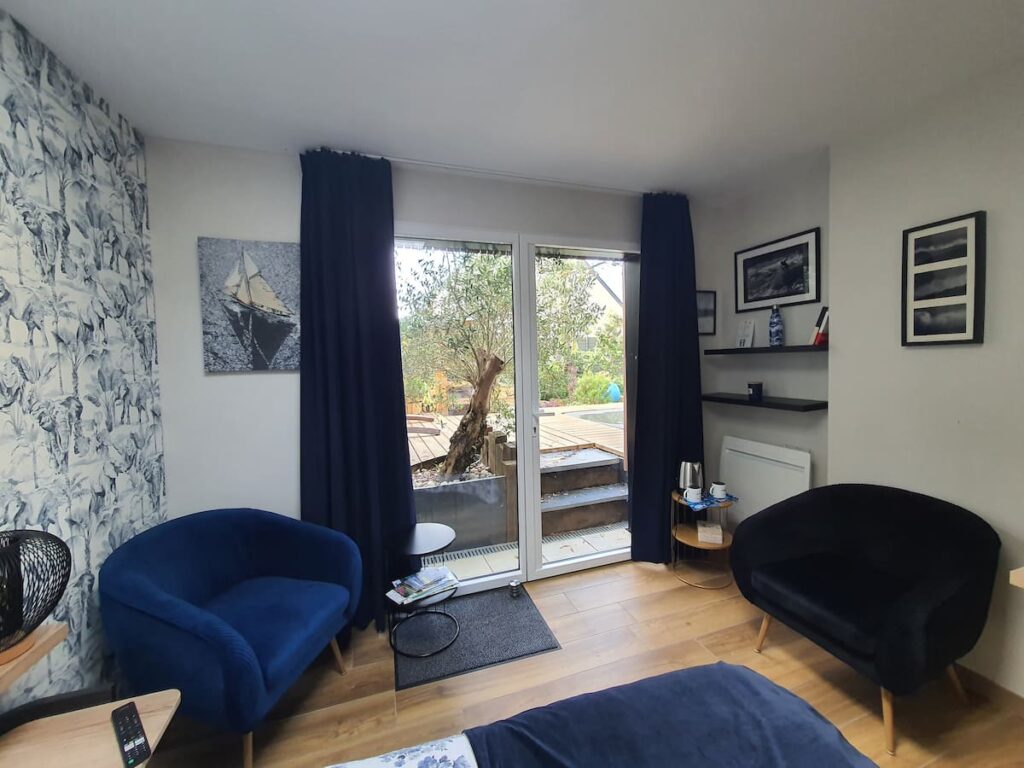 Dans votre chambre Ki Bleiz, un espace petit salon avec deux fauteuils très confortables pour regarder un film ou faire une pause "tea time" face au jardin, aux oliviers et aux roses.