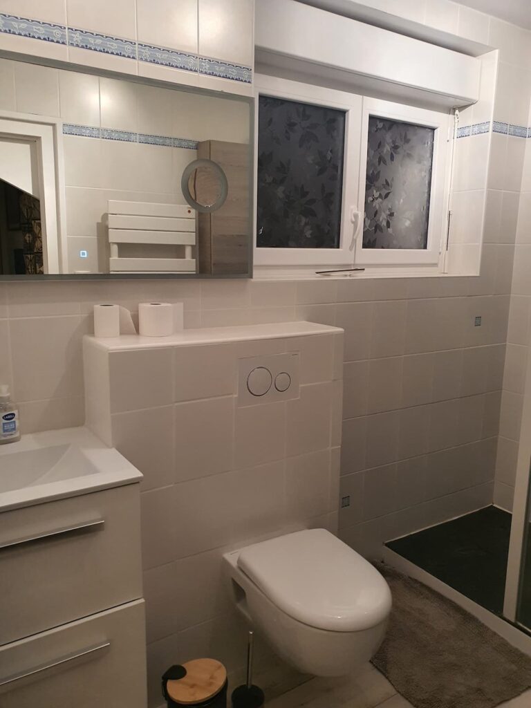 Salle de douche avec fenêtre donnant sur le jardin.