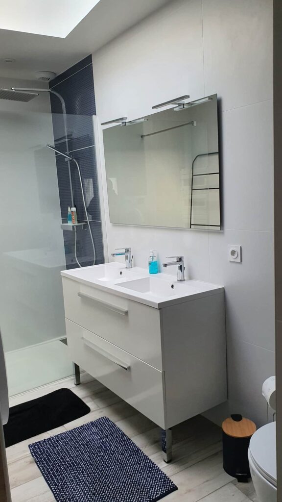 Une salle de douche spacieuse et lumineuse totalement équipée avec un sèche serviette, un sèche linge, une double vasque , un WC suspendu, une VMC, un skydom.