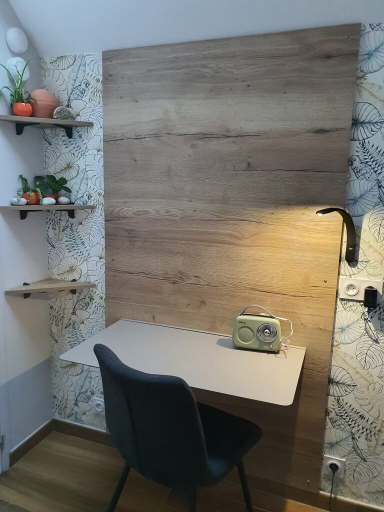Un bureau avec un luminaire connecté sous un velux lumineux. Des conditions confortables pour télétravailler.