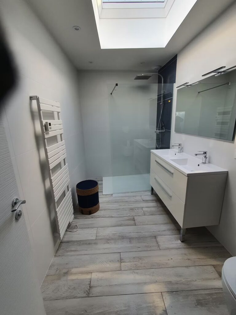 Grande salle de douche lumineuse avec peignoirs, serviettes, gel douche, sèche serviette à votre disposition.